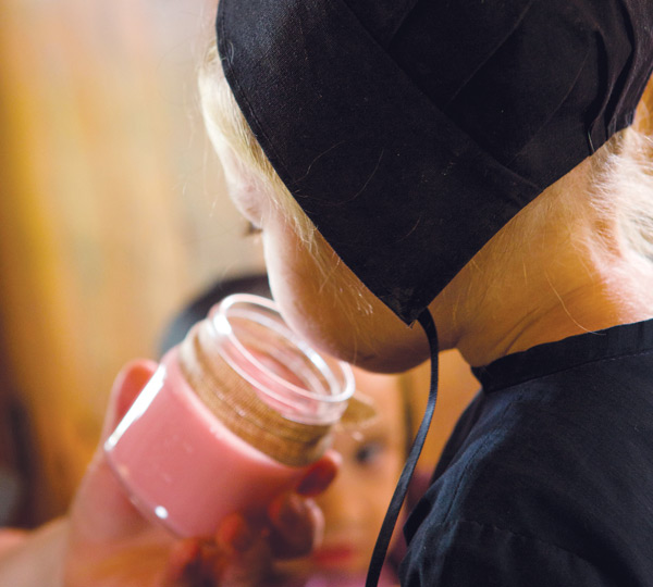 Amish girl smelling candle