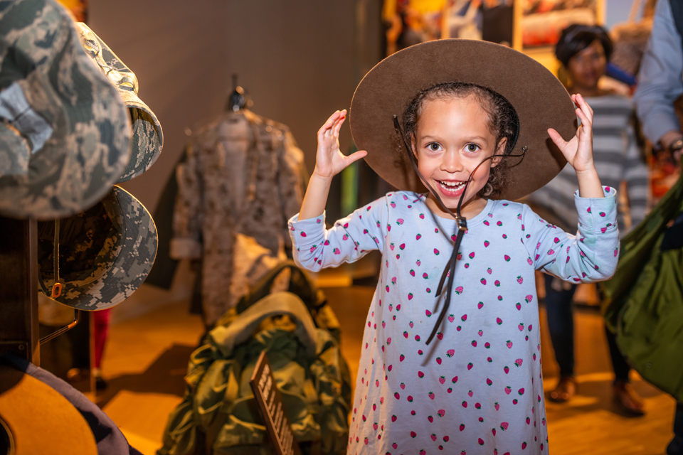 Child tries on hat