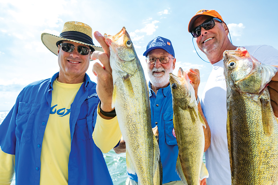 Three men holding fish up (photo by Laura Watilo Blake)