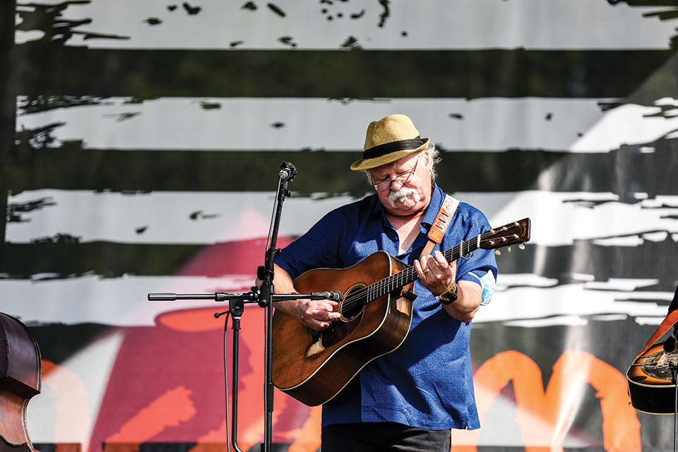 Man playing guitar at SamJam Bluegrass Festival (photo by Jennifer Buckler) Man playing guitar at SamJam Bluegrass Festival (photo by Jennifer Buckler)