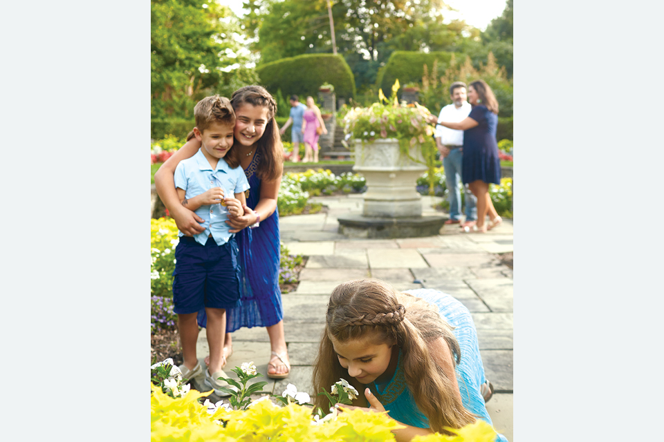 Girl smelling flowers at Kingwood Center Gardens (photo by Casey Rearick)