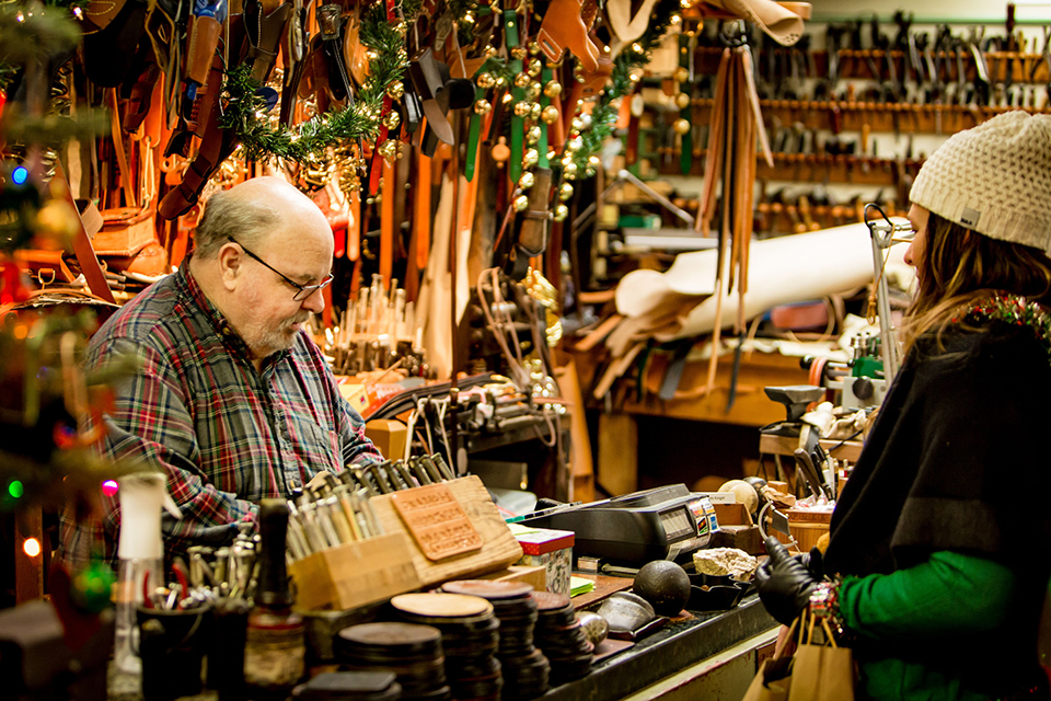 Woman at checkout counter at shop during Christmas Candlelighting at Roscoe Village in Coschocton (photo courtesy of Historic Roscoe Village)