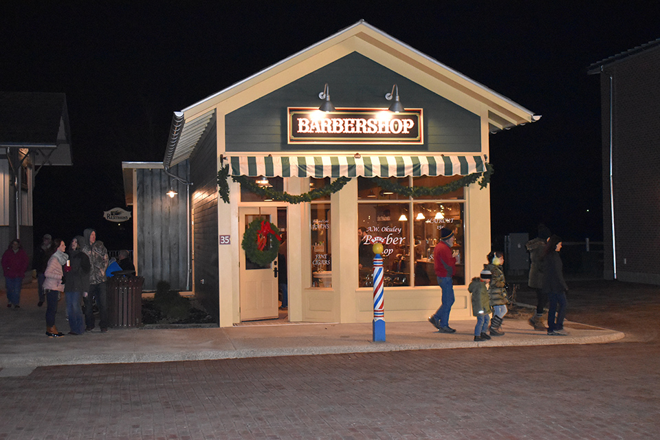 Archbold’s Sauder Village barbershop exterior at night decorated for “1920s Holidays on Main Street”