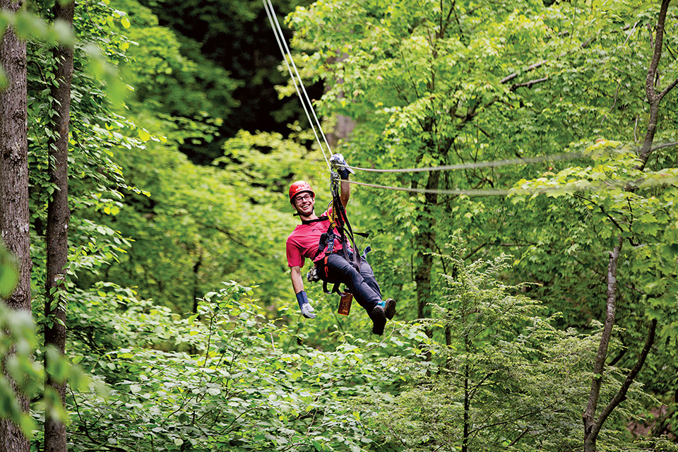Man zip lining at Adventure on the Gorge’s TreeTops Zipline Canopy Tour in Lansing (photo courtesy of West Virginia Department of Tourism)