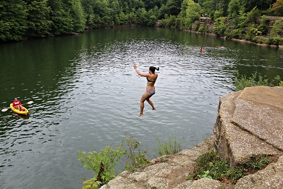 Woman jumping into water at Nelson Ledges Quarry Park in Garrettsville (photo by Scott Ash)