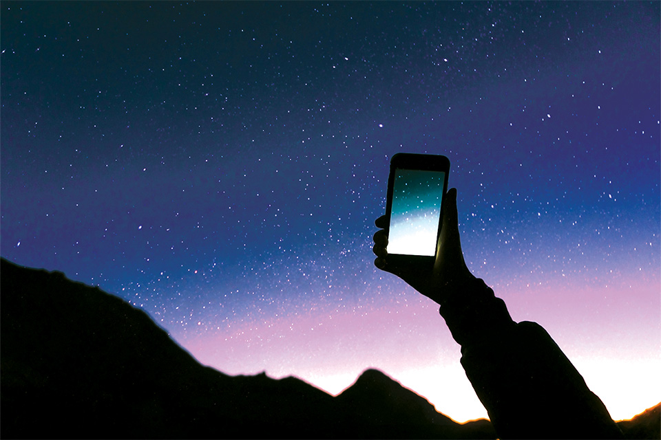 Person doing smart phone photography of night sky (photo by iStock)