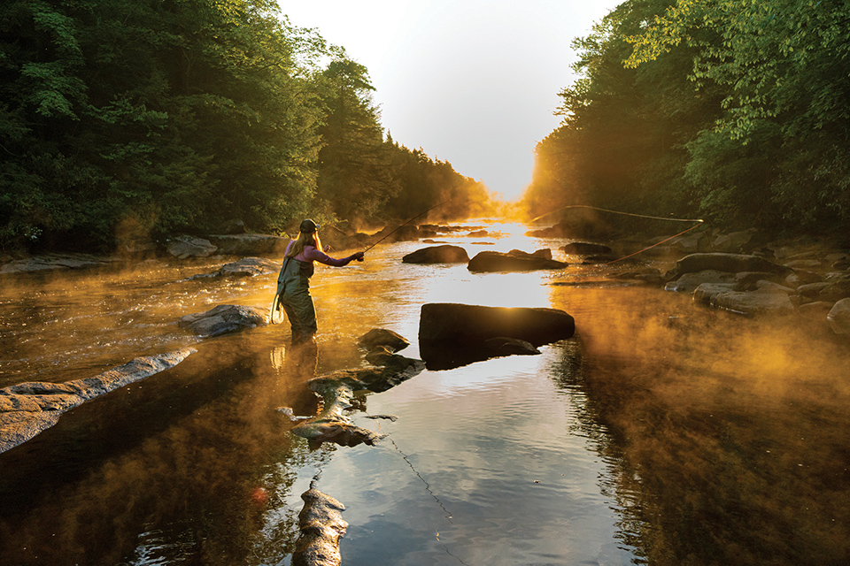 Woman fly fishing on river in Tucker County, West Virginia (photo courtesy of Tucker County Visitors Bureau)