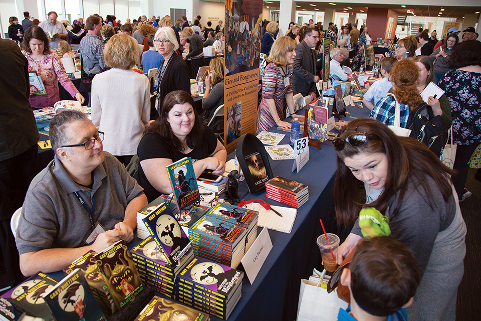 Authors sitting at booths at Columbus’ Ohioana Book Festival (photo by Mary Rathke)