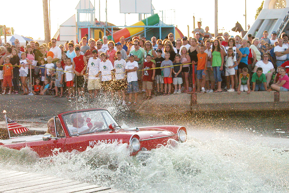 People driving amphicar into water at the Celina Lake Festival (photo courtesy of Grand Lake Region Visitors Center)