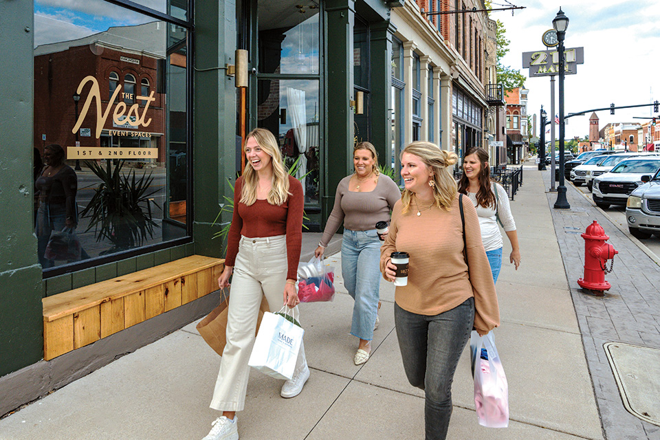 Women with shopping bags walking in downtown Celina (photo by Doug Hinebaugh)