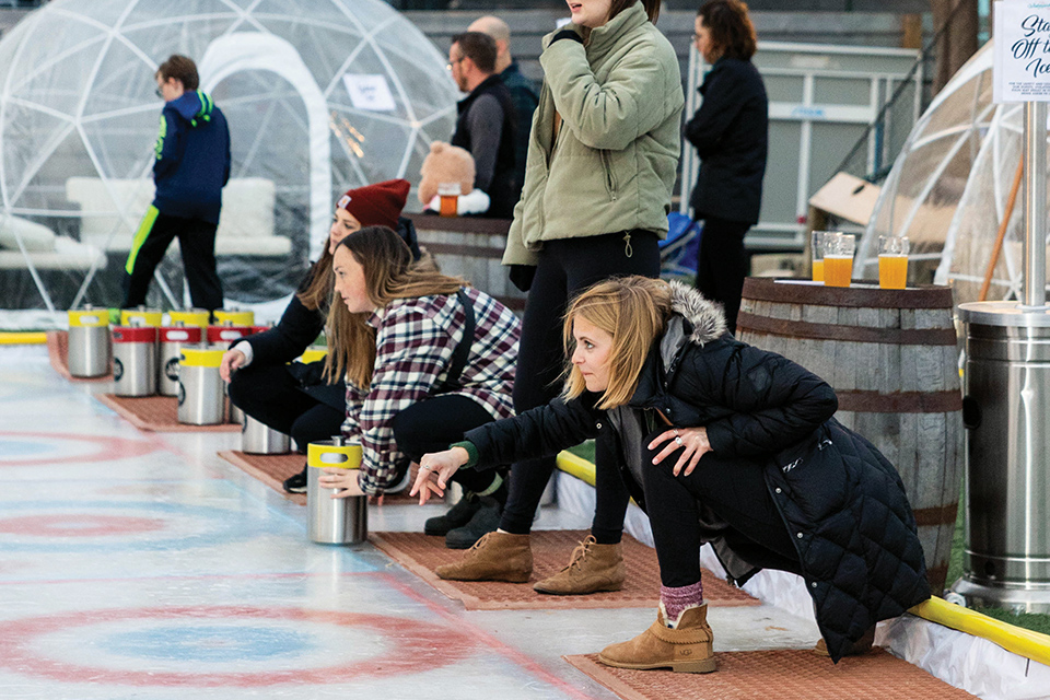 People doing keg curling on the ice rink at Columbus’ Land-Grant Brewing Co. (photo courtesy of Land-Grant Brewing Co.)