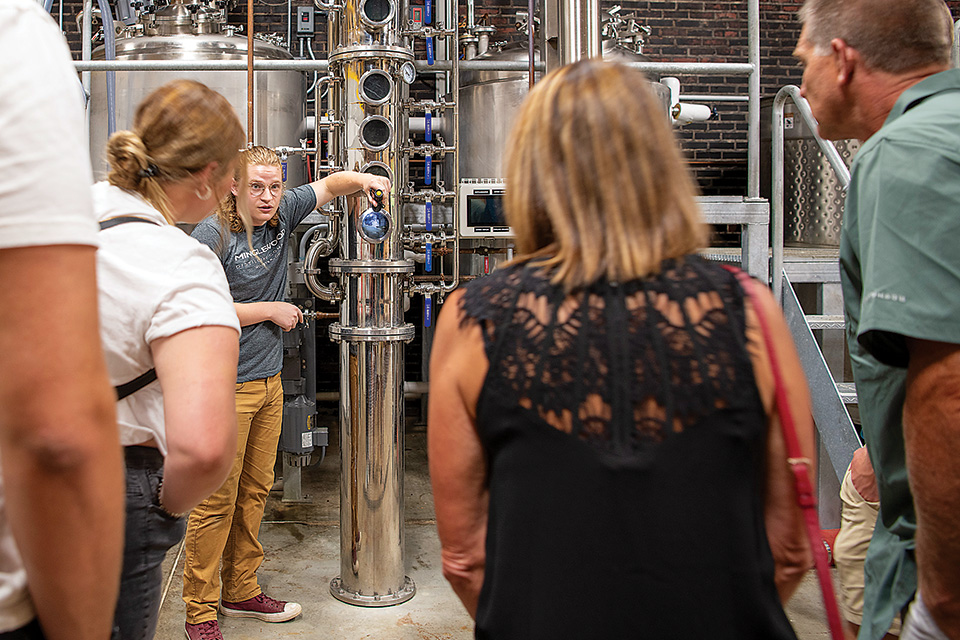 Crowd watching demonstration of distillery machine at Minglewood Distilling Company (photo by Wendy Pramik)