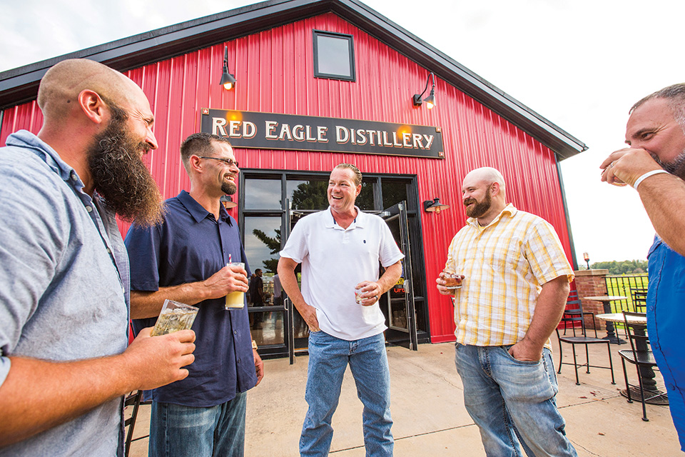 Men talking and drinking at Red Eagle Distillery in Geneva (photo by Chris Casella)