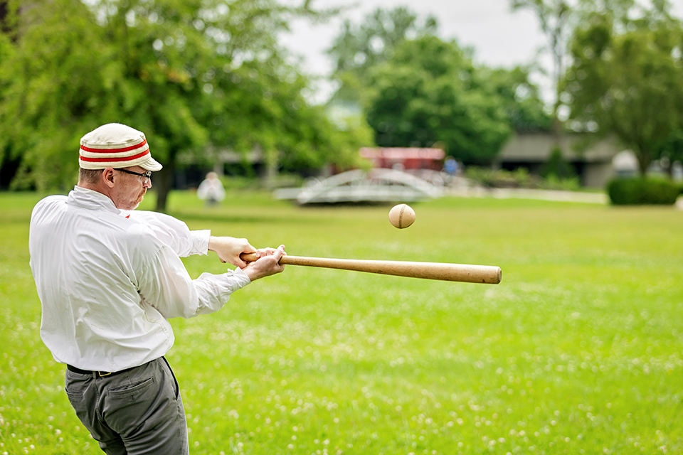 Man hitting a baseball in vintage baseball at Ohio Village in Columbus (photo courtesy of Ohio History Connection)