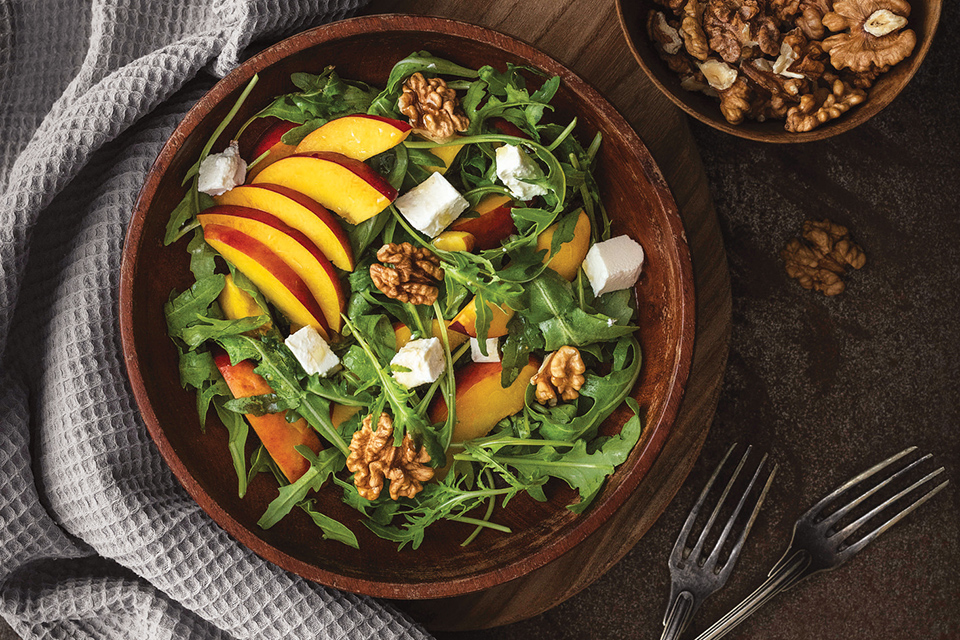 Salad with walnuts, leafy greens, tofu and peaches (photo by iStock)
