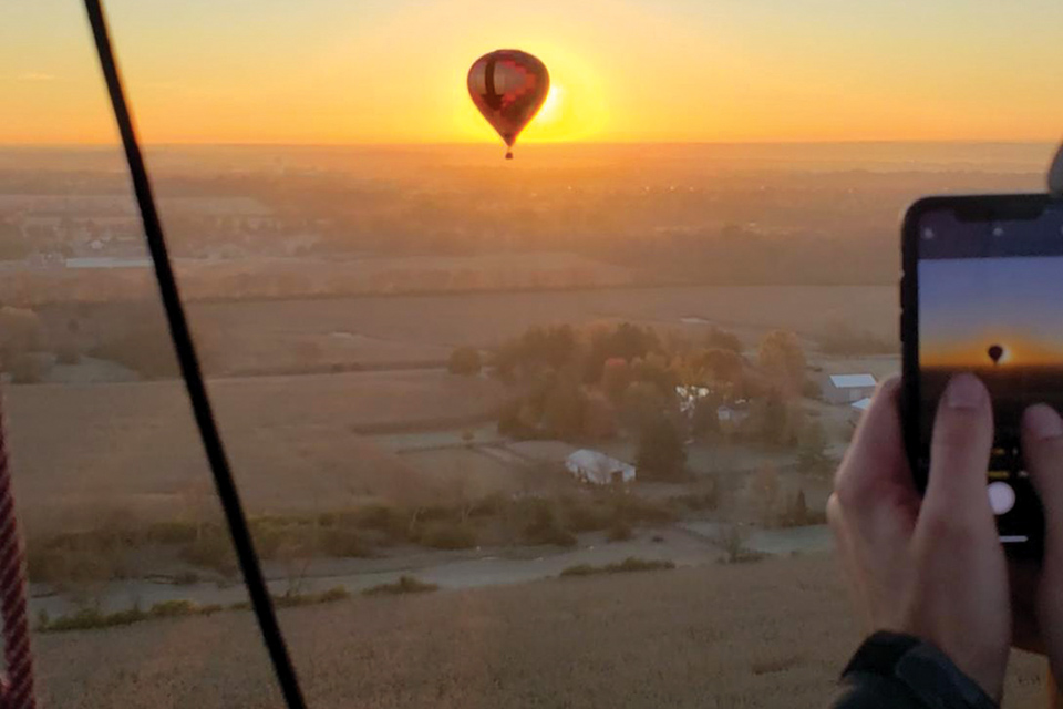 Hot air balloon rider taking photo of another balloon over southwest Ohio (photo courtesy of Gentle Breeze Hot Air Balloon)