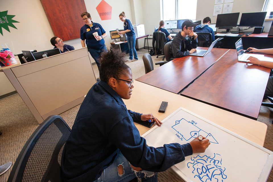 Student drawing diagram in classroom (photo by Doug Garmon)