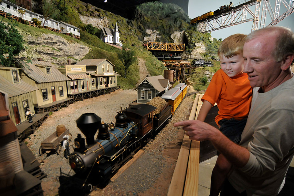 A family looks at one of the trains at Entertrainment Junction (photo courtesy of Entertrainment Junction)