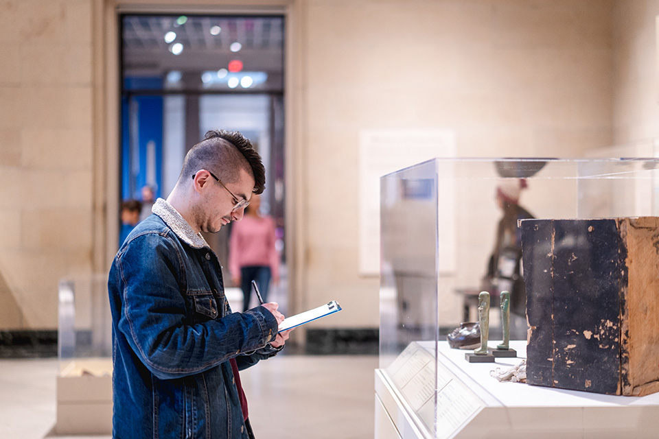 A visitor channels their creativity by sketching masterpieces on display during the Great Art Escape.