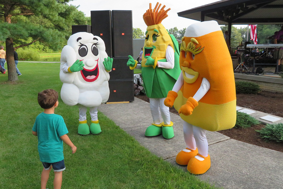 Child with Costumed Characters at the North Ridgeville Corn Festival (photo courtesy of North Ridgeville Corn Festival)