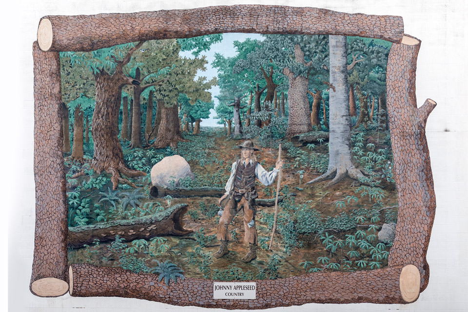 A mural depicting John “Johnny Appleseed” Chapman standing in a forest (photo courtesy of Library of Congress)